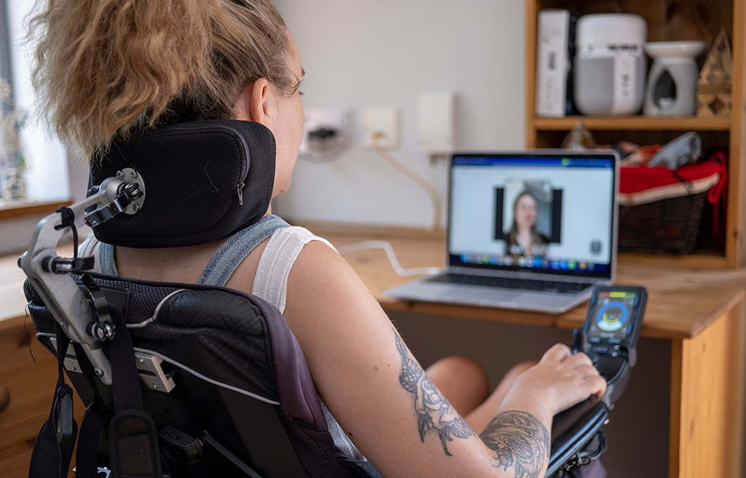 Disabled female watching an instructional video on her laptop.