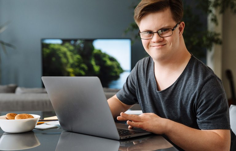 Young man with Down Syndrome working on their laptop.